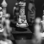 Black and white chess scene with a rook being strategically moved on the board.